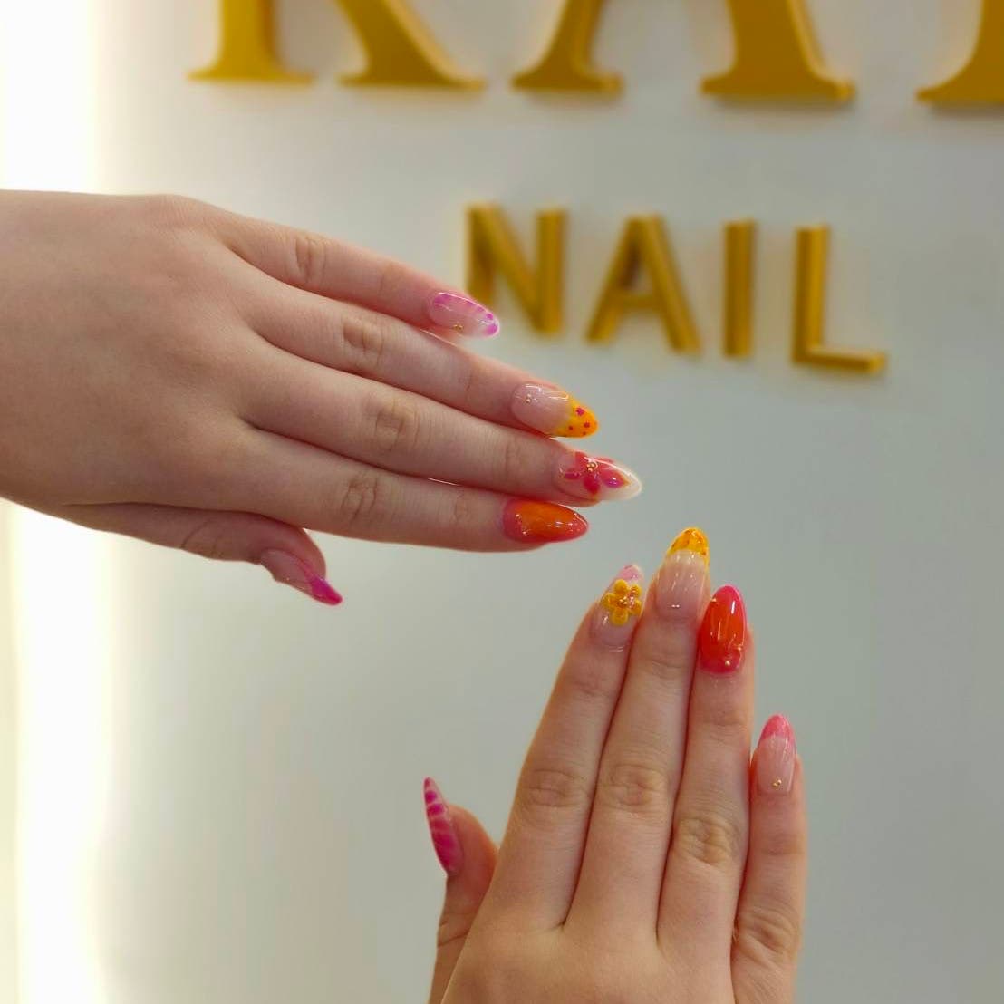 Orange and pink nail art in front of the lounge logo