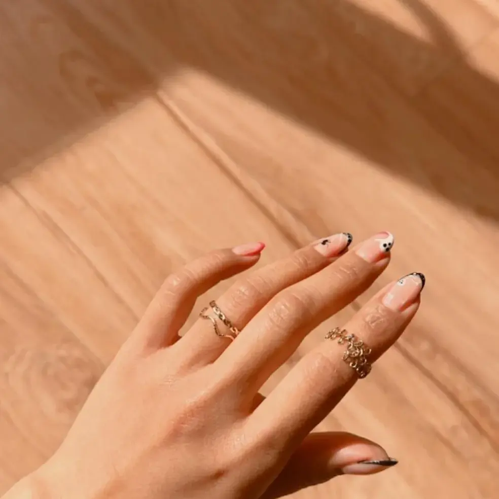 Black and white nail art photographed on a wooden floor