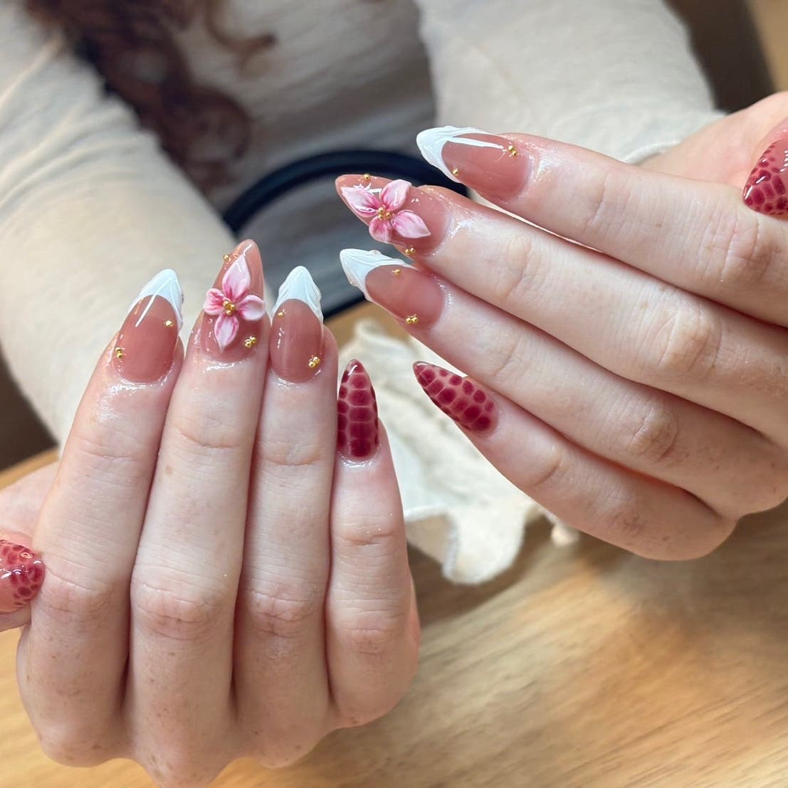 Floral gel nail art with red and gold accents