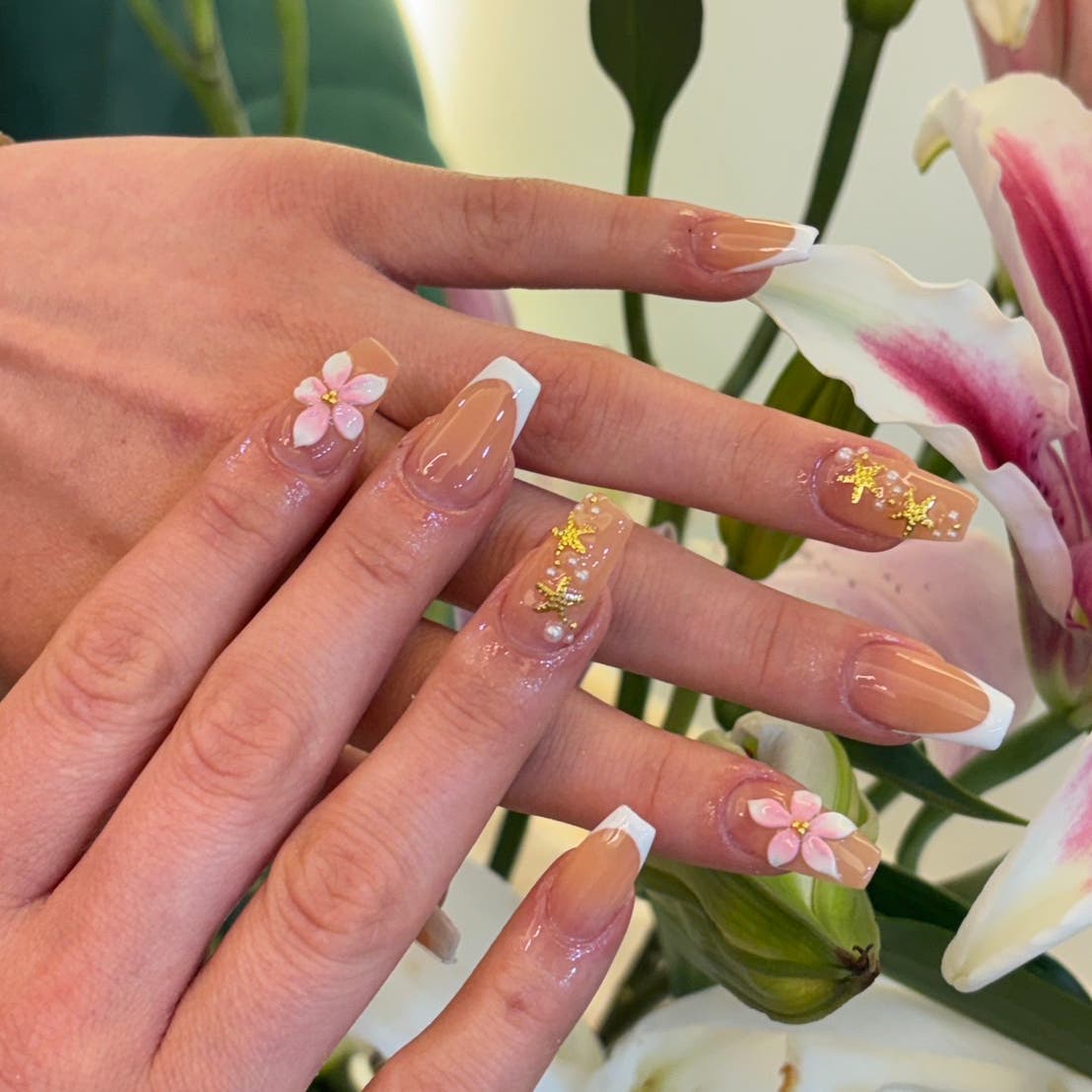 Gold floral accents on pink nails