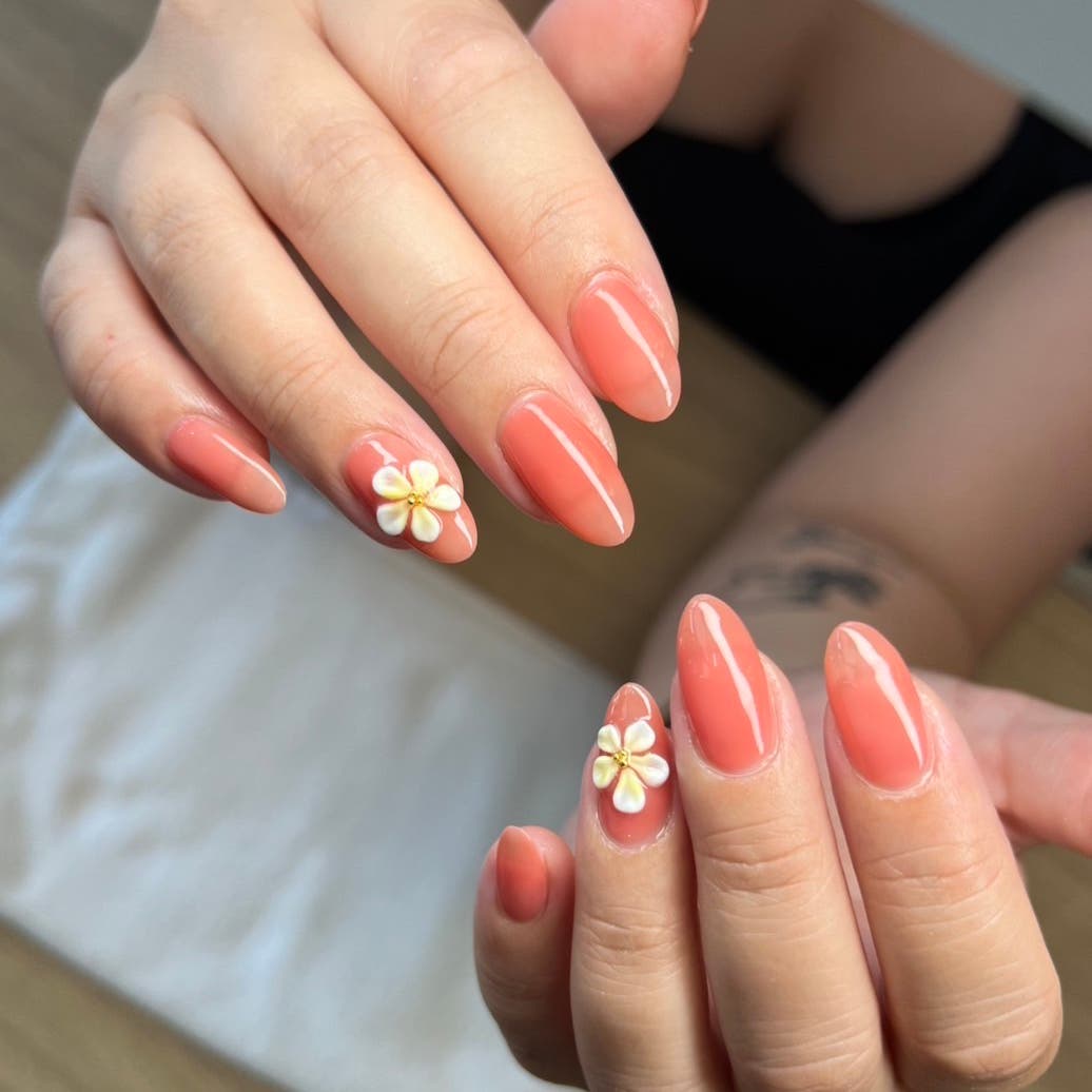 Coral nails with white flower accents